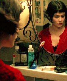 a woman is looking at her reflection in the mirror