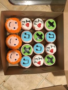 six cupcakes in a box with faces and letters on them, all decorated to look like people