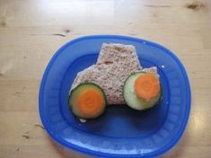 a blue plate topped with two slices of cucumber and an orange piece of bread