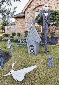 halloween yard decorations in front of a house with skeletons and tombstones on the lawn