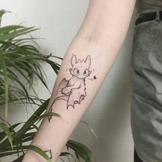 a person with a tattoo on their arm holding a potted plant in front of them