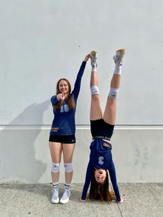 two girls doing handstands on their heads while standing in front of a wall