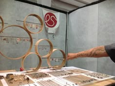 a man standing in front of a display of rings and necklaces on a table