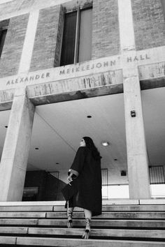 a woman standing on the steps in front of a building