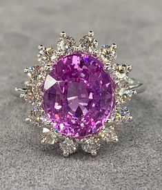 ALL THESE PHOTOS WERE TAKEN WITH AN ORDINARY IPHONE & HAVE NOT BEEN EDITED OR ENHANCED IN ANY WAY. Up for sale is a Stunning Natural Unheated Pink Sapphire & Diamond Halo Ring in solid 18K White Gold. This Ring was made by us Here in New York City & is of the Finest Quality.  The Center Stone is a Beautiful Natural GRS Certified 5.00 Ct Oval Cut Pink Sapphire that measures approx 11 x 9 mm, was mined in Madagascar & Has NOT Been Heated or Treated in Any Way. It has a very attractive Bright Pink Luxury Purple Cubic Zirconia Rings, Luxury White Gold Brilliant Cut Amethyst Ring, Luxury White Gold Amethyst Ring With Multi-stones, Luxury Multi-stone Amethyst Ring In White Gold, Luxury Platinum Amethyst Ring For Anniversary, Luxury Amethyst Ring With Halo Setting For Anniversary, Luxury Halo Ring For May Birthstone Gift, Luxury Platinum Amethyst Wedding Ring, Luxury Halo Birthstone Ring As Gift