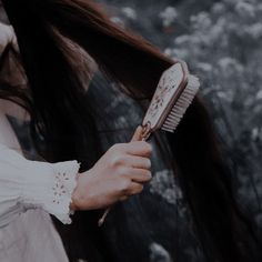 a woman holding a hair brush in her hand