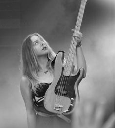 a woman holding a guitar up to her face