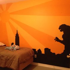 an orange and black bedroom with a king kong mural on the wall next to a bed