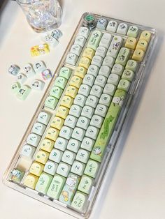 a white and yellow keyboard sitting on top of a table next to some diced objects