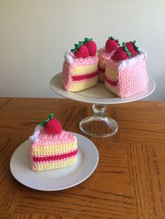 two pieces of cake sitting on top of plates next to each other with strawberries