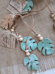 the necklace is decorated with green leaves and beads on a burlap tablecloth