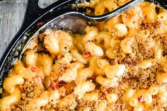 macaroni and cheese casserole in a black dish with a serving spoon