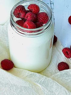 a jar filled with yogurt and raspberries on top of a table