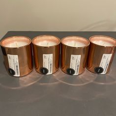 four copper colored candles sitting on top of a table