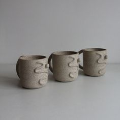 three mugs sitting next to each other on a table