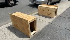 two wooden boxes sitting on the side of a road