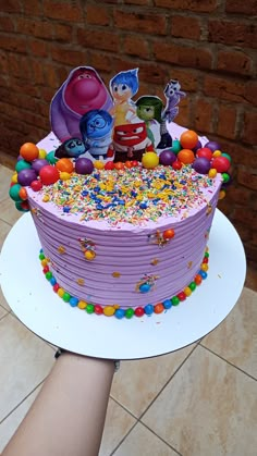 there is a cake that has sprinkles on it and some characters on top