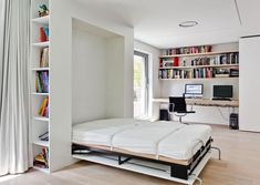 a bedroom with a bed, computer desk and bookshelf in the corner next to windows