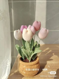 a crocheted potted plant with pink and white flowers