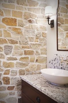 a white bowl sink sitting on top of a counter next to a wall mounted mirror