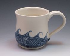 a white and blue coffee cup with waves on it