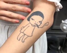 a woman's arm with a tattoo on it that has a drawing of a girl