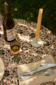 a bottle of wine sitting on top of a table next to a knife and fork