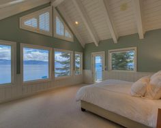 a large bed sitting in a bedroom next to two windows