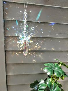 a glass chandelier hanging from the side of a house next to a potted plant