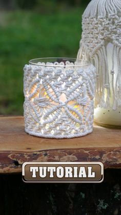 a white candle holder sitting on top of a wooden table next to a glass jar