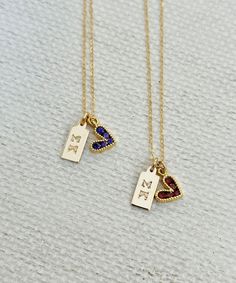 two gold necklaces with initial charms on them