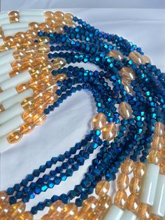 Double Strand Waist Bead "Koffikro" features two strands adorned with rich, deep blue glass seed beads. Dive into the enchanting allure of this accessory, designed to add a touch of sophistication and mystery to your style. 🌌 Blue : Immerse yourself in the deep and luxurious shades of blue that adorn each strand of this waist bead. The profound color symbolizes tranquility and depth, making it a perfect choice for expressing your inner calm and timeless elegance. 🌟 Double Strand: The double strand design adds a layer of opulence and texture, creating a visually stunning and intricate accessory. The strands cascade gracefully, allowing you to make a bold and refined statement with every movement. 🔵 Versatile Expression: Whether worn under clothing for a discreet touch or as a visible sta Blue Czech Glass Beaded Chain, Elegant Blue Faceted Beads, Blue Double Strand Beaded Necklace With Polished Beads, Multi-strand Blue Beads For Jewelry Making, Blue Multi-strand Elegant Beads, Blue Multi-strand Beads For Jewelry Making, Elegant Multi-strand Blue Beads, Multi-strand Polished Czech Glass Beads, Blue Beaded Bracelets With Faceted Oval Beads