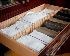 an open drawer with several shirts in it