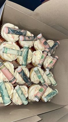 cupcakes decorated with money are in a box