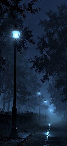 a street light sitting on the side of a road at night with trees in the background