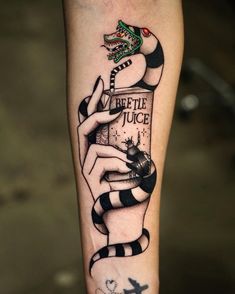 a woman's arm with a tattoo on it and a snake holding a bottle