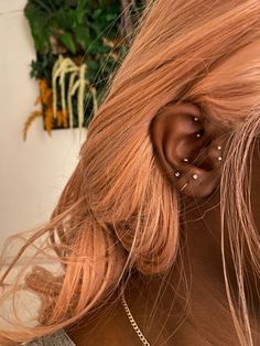 a woman with blonde hair wearing a pair of ear piercings