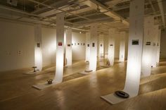 an empty room with wooden floors and white columns on the walls, lights in the ceiling