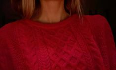 a woman in a red sweater holding a cell phone