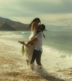 a man carrying a woman on his back at the beach