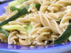 a blue plate topped with pasta and veggies