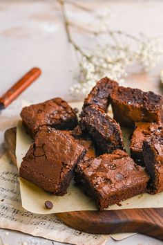 chocolate brownies sitting on top of a wooden cutting board