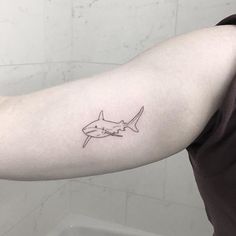 a man's arm with a tattoo of a shark on it