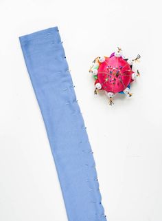 a blue piece of cloth next to a pink object on top of a white surface