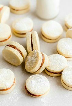 some cookies and other pastries on a white surface with powdered sugar around them