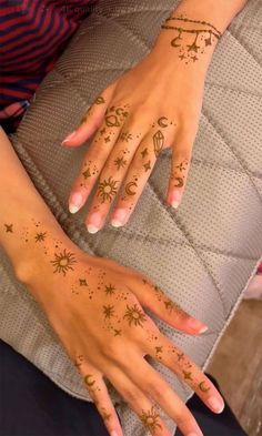 a woman's hand with tattoos on it and stars in the middle of her fingers