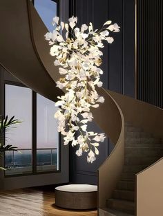 a modern chandelier with white flowers hanging from it's spiral metal frame