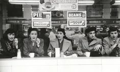 black and white photograph of people sitting at a counter