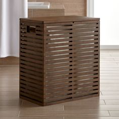 a brown trash can sitting on top of a tiled floor