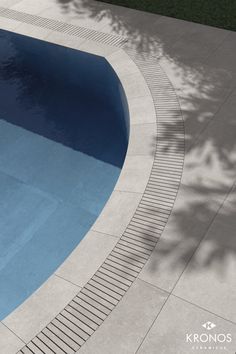 an empty swimming pool surrounded by grass and trees